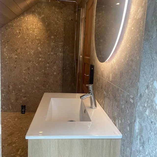 Nyoppusset bad med fliser på vegg og servant