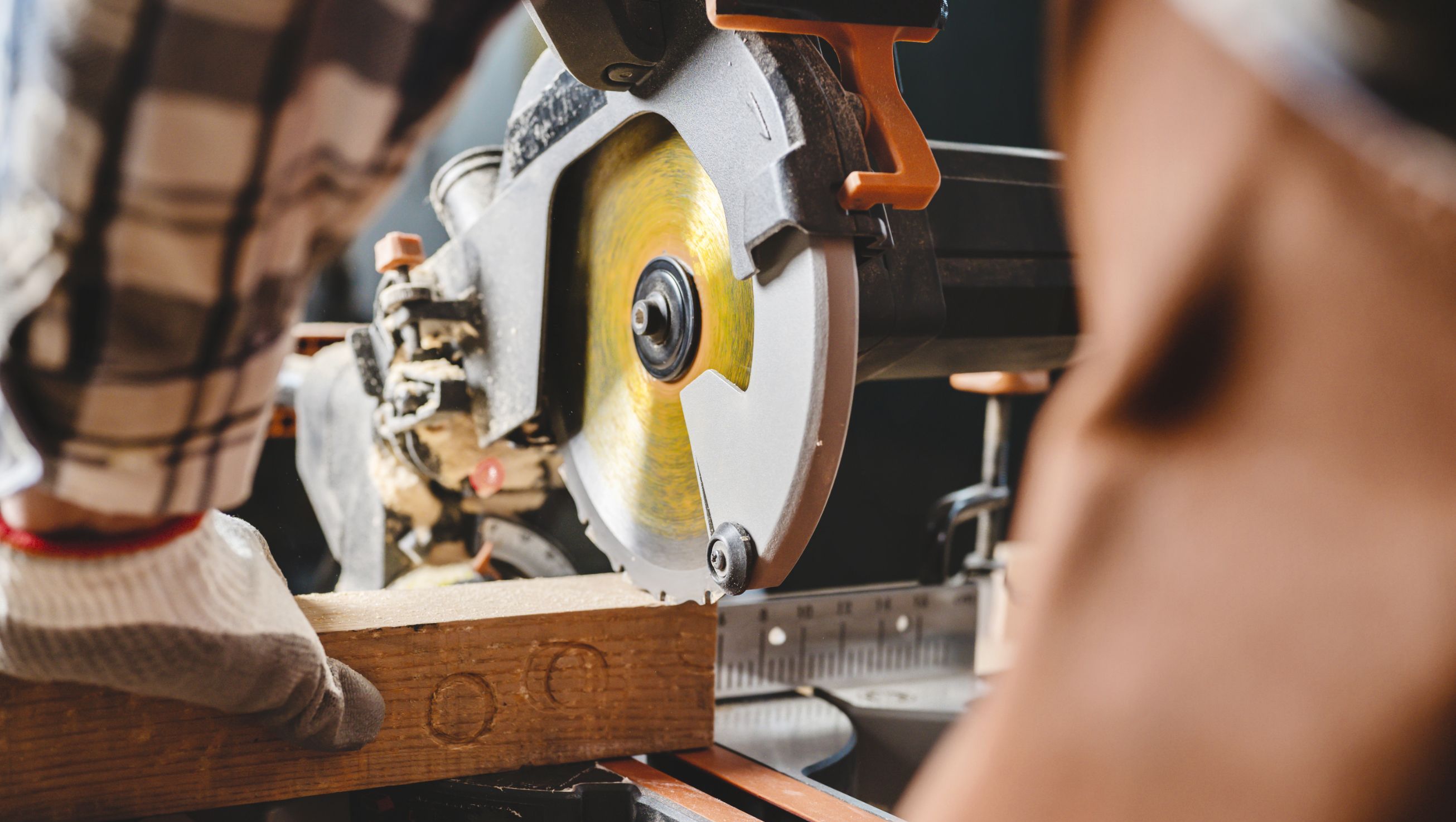 Snekker bruker kappsag for å kappe planke